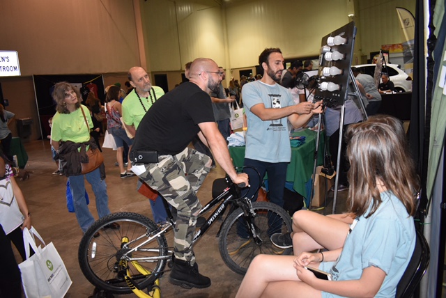A fairgoer rides a bike to produce energy to light up a set of light bulbs.  The Earth Day Fair gave people the opportunity to learn about alternative energy sources.