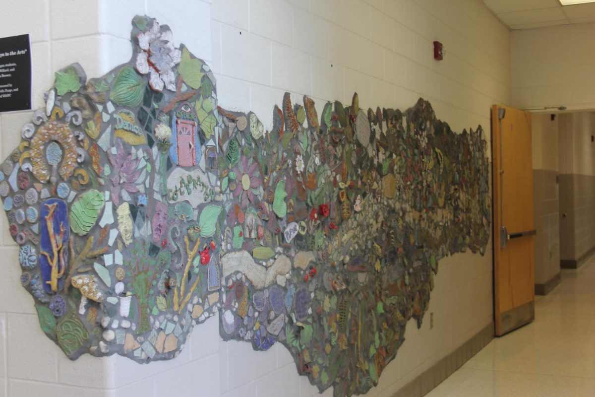 Pathways and Portals to the Arts displays themes of water, land, paths, greenery, and portals. The display was created by the art classes. 