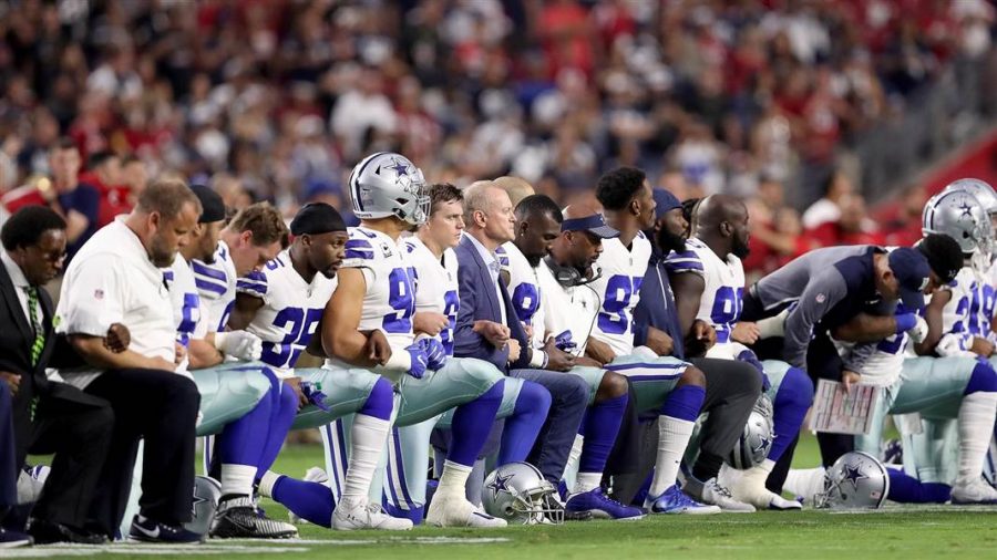 Dallas Cowboys owner Jerry Jones takes a knee during the National Anthem with his team Monday, September 25.