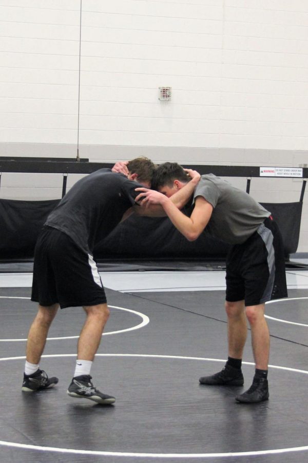 Two team members wrestling during scrimmage against East Forsyth