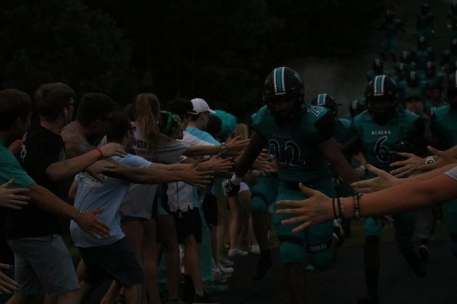 Christian Hicks leads the Raider football team down the hill before the Tabor game. Reagan played Tabor on Sept. 7.