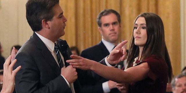 Acosta+refuses+to+give+up+the+mic+as+a+young+intern+attempts+to+take+it.+He+continued+to+bash+Trump+and+his+policies+during+the+meeting.