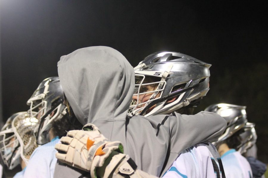 On a rare break, senior Kevin Carr embraces one of his friends while watching his teammates battle out on the field. “My favorite part of the lacrosse team is that we can take players with little experience and make them become a huge part of the team,” Carr said. “We can count on them to step up when we need them.”