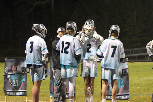 During halftime, Coach Quinn Kuhn pulls a few of the players from the group to discuss the game. Due to their hard work, the men’s varsity team triumphed over Davie 16-4 on Senior Night.