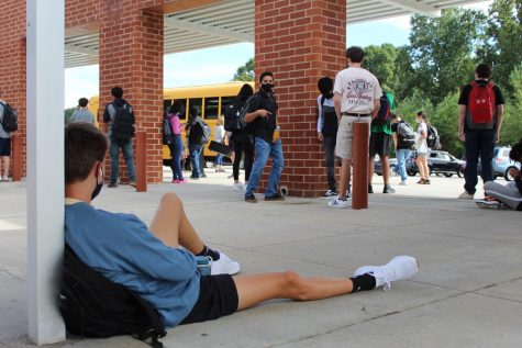 Ethan Stewart sits against a pillar as he waits for his bus on Sept. 17, 2021. Students at Reagan have had to wait until 5:30 p.m. for buses to arrive.