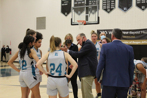 During a timeout call, head coach Eric Rader gathers the varsity women’s basketball team to discuss strategy. The Reagan Raiders played the South Rowan Raiders on Nov. 30.

