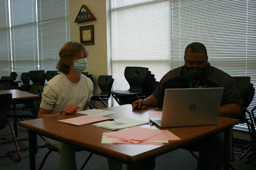 Freshman Ian Hill discusses class registration with counselor Chris McCoy. In the month of February, all Reagan students will register for their class schedule for the 2022-23 school year 