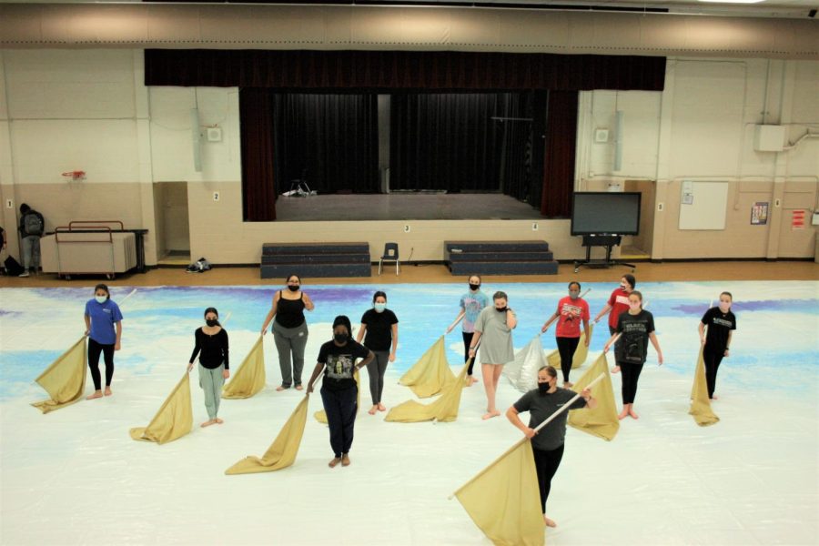 The Reagan winterguard stands together in their routine's final pose during a practice. The winterguard won their most recent competition despite beginning practices late in the season. 